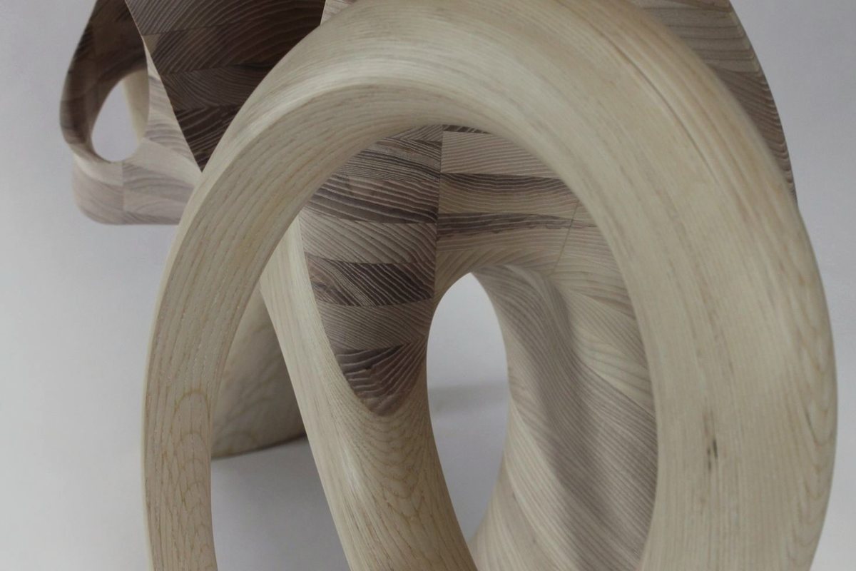 Aeolian — an ash console carried on interlocking carved loops