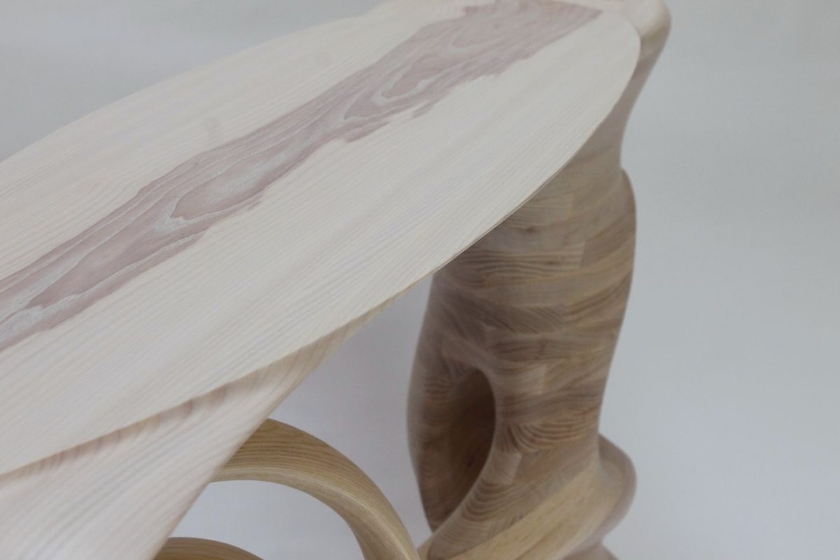Reinga — an ash console table, its top balanced on a coiled leg