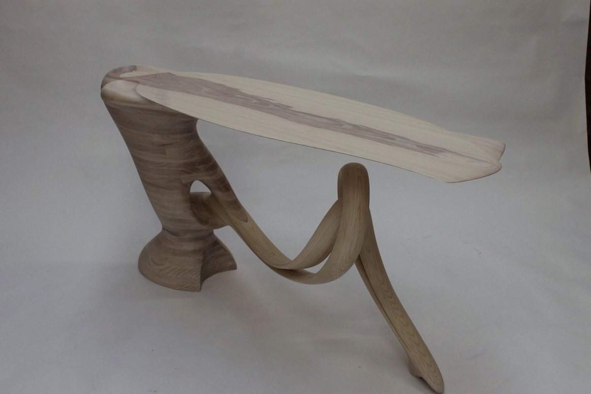 Reinga — an ash console table, its top balanced on a coiled leg