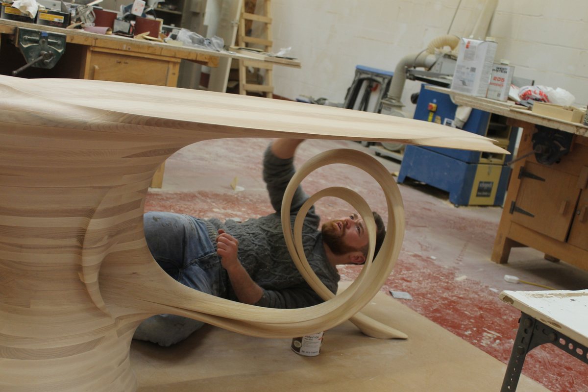 Reinga — an ash console table, its top balanced on a coiled leg
