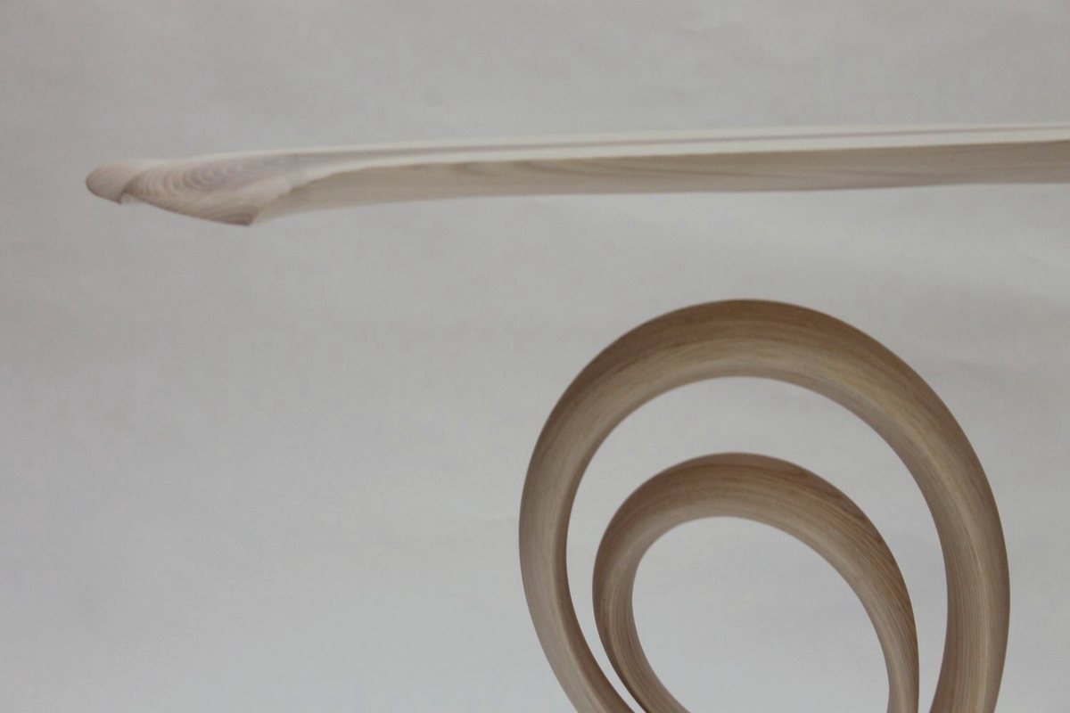 Reinga — an ash console table, its top balanced on a coiled leg