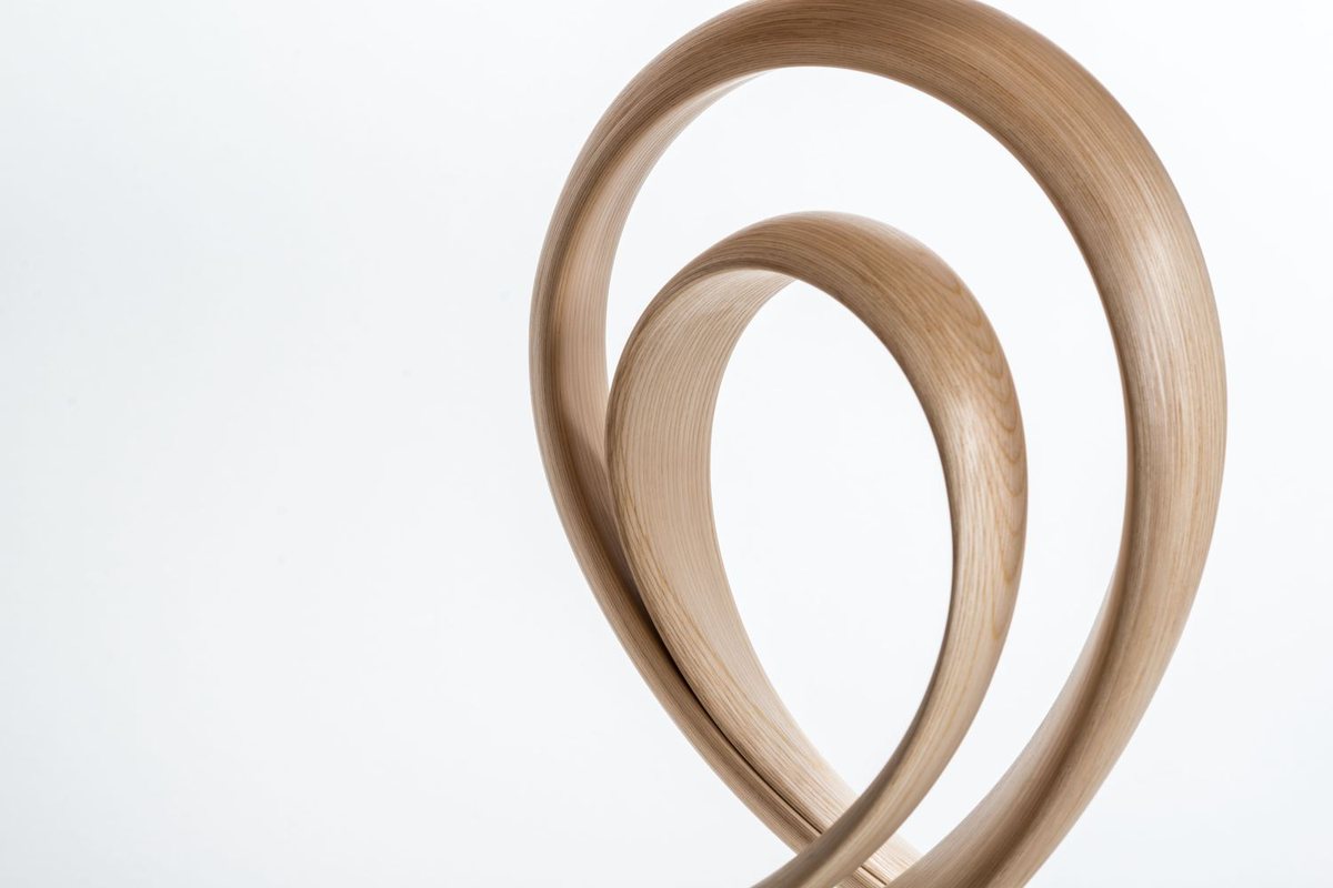 Waiho — a console table in ash, its top carried above a curling ribbon leg